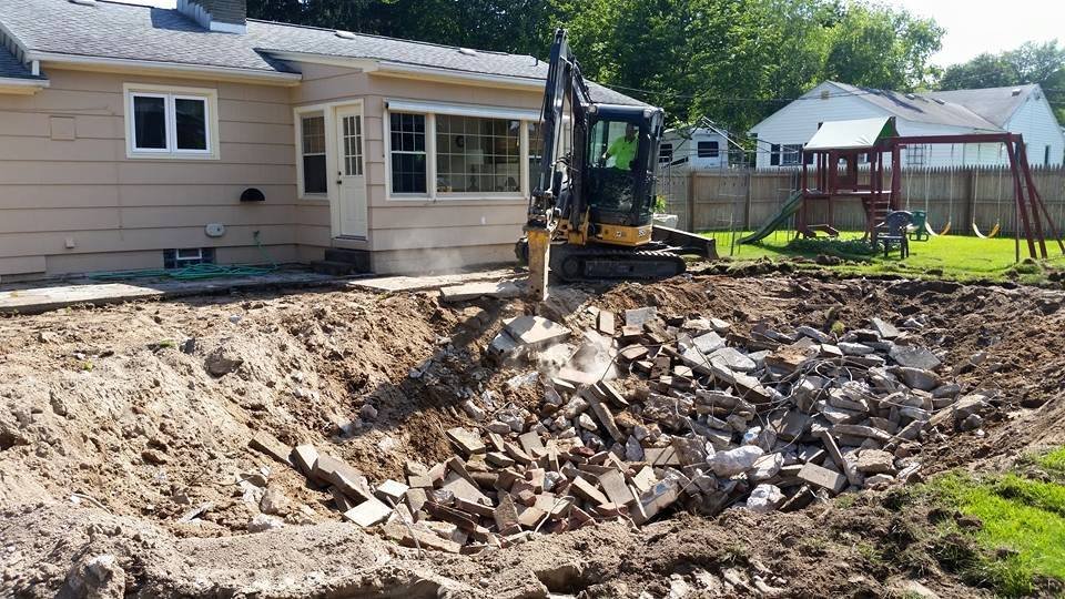 Excavator digging in a backyard for a water service installation
